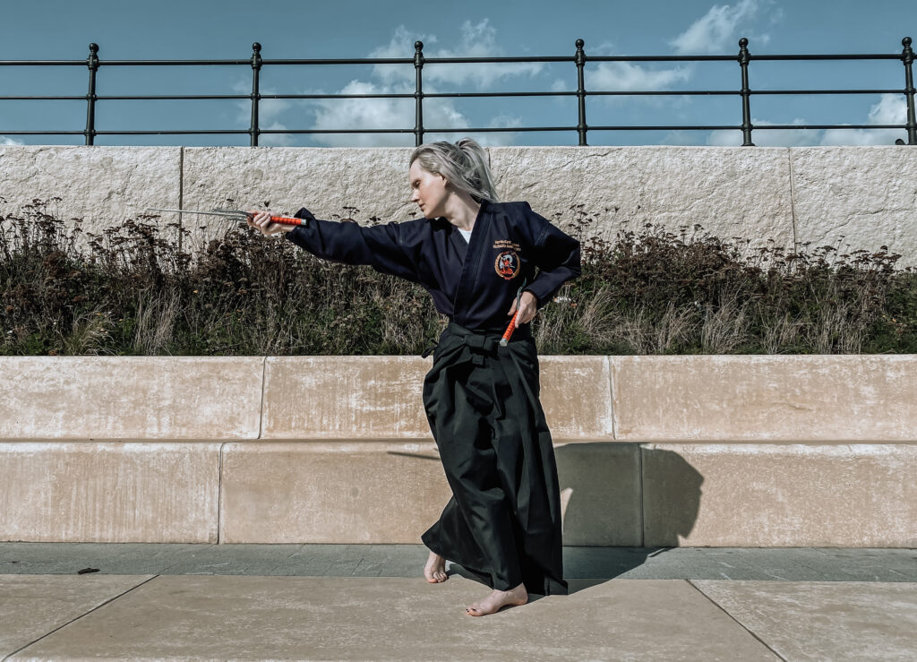 A girl doing martial arts with sai