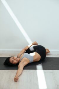 woman doing supine twist yoga pose